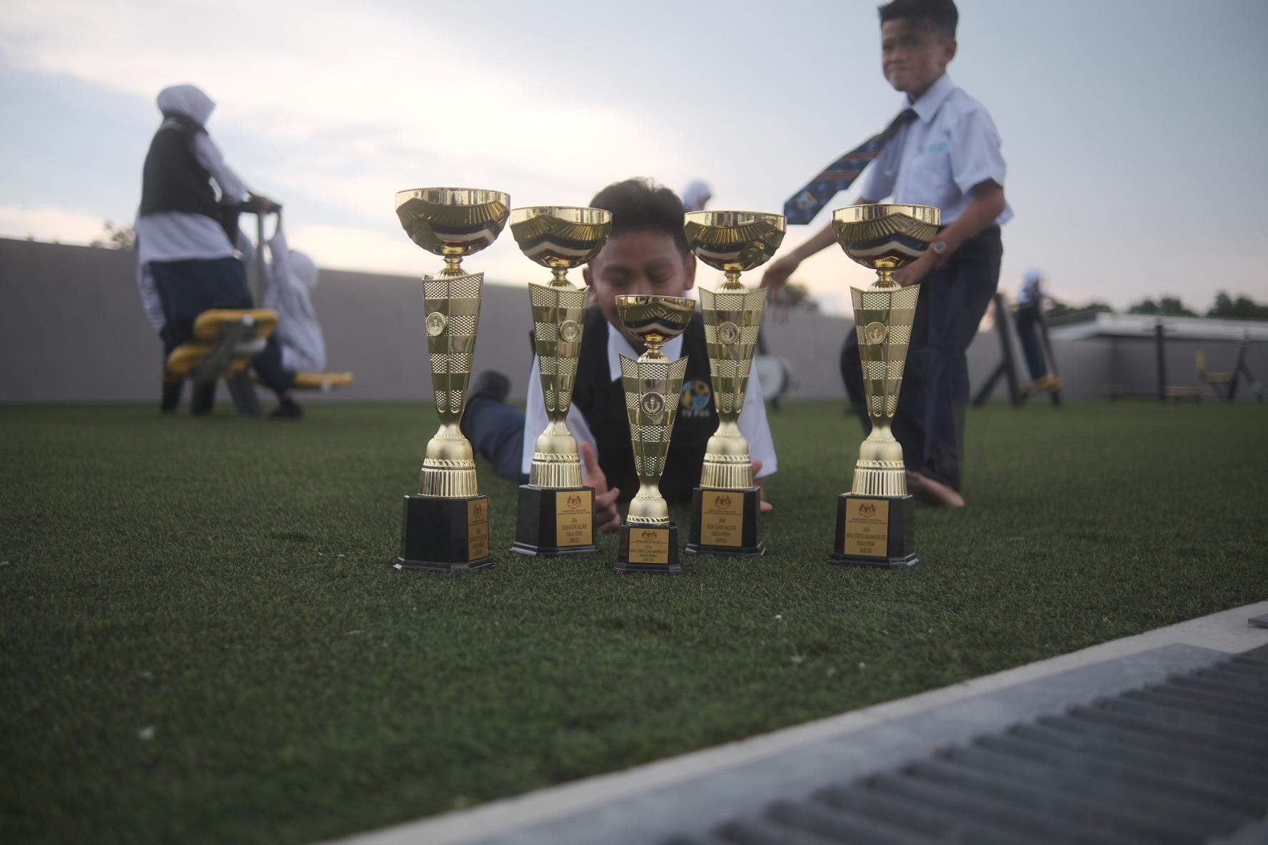 Trophies on a school sports field, from Izuan’s portfolio